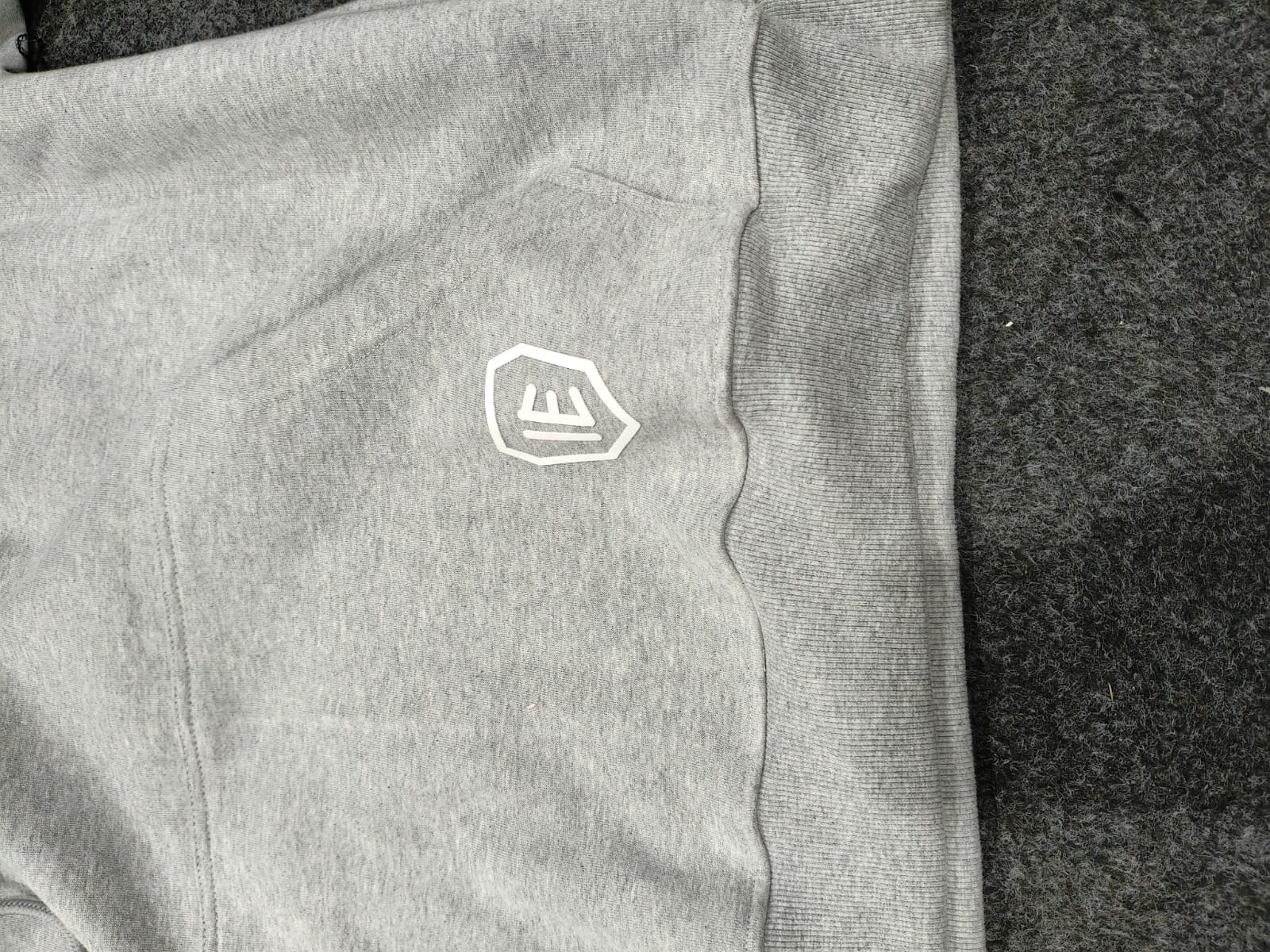 Close detail of the Gray Minimal Hoodie shield and heavyweight fleece