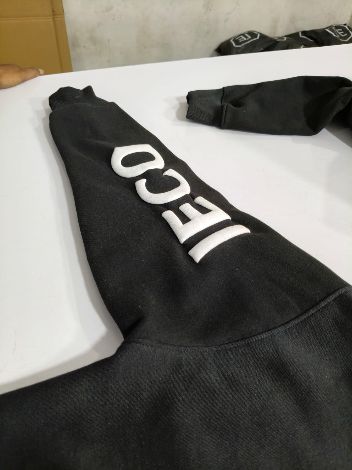 Close detail of the dimensional IECO puff print on the right sleeve